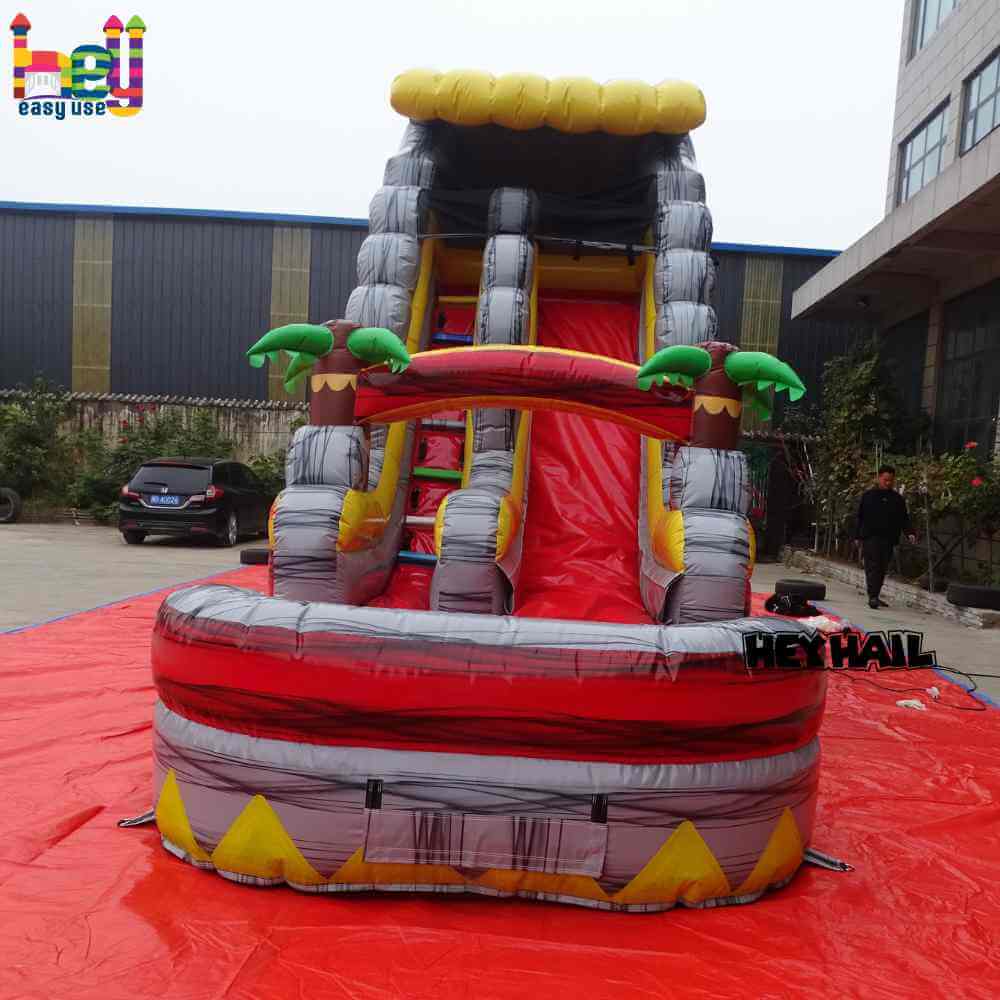 Front view of red gray yellow single lane water slide with front pool and palm-tree accents