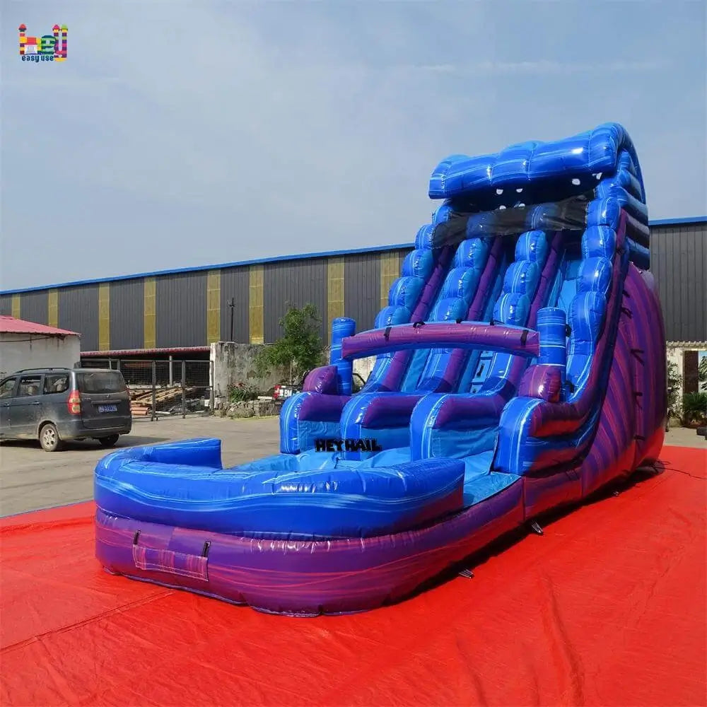 Angled outdoor view of a marble blue-and-purple dual-lane inflatable water slide with a front landing pool