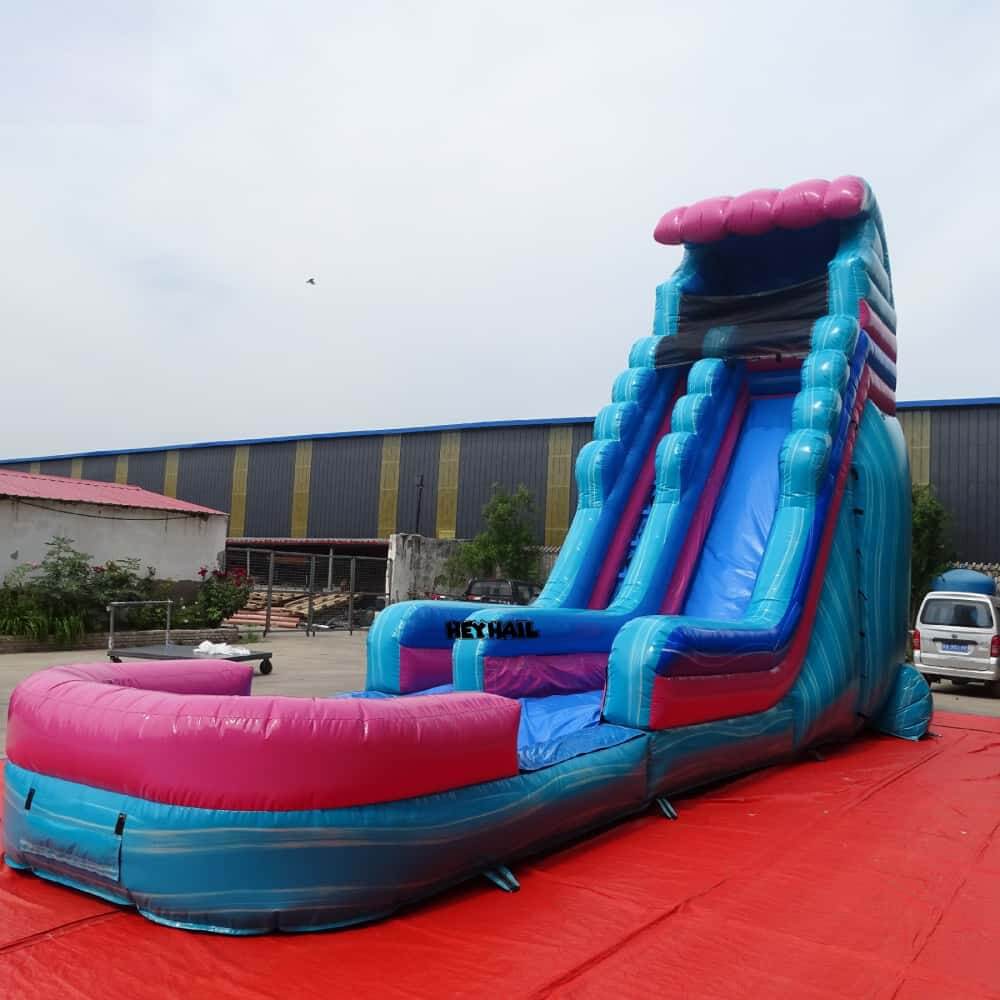 Angled view of pink and blue 22ft single lane water slide and landing pool