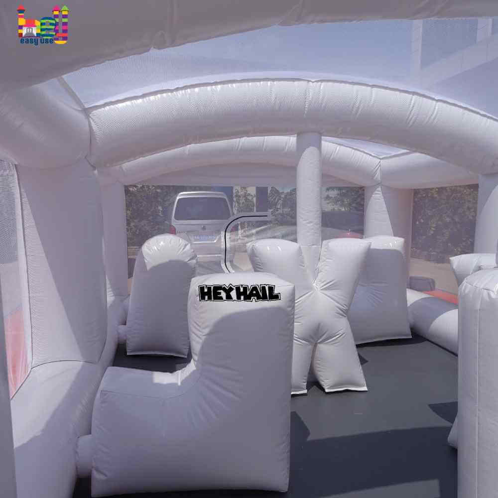 Interior view of white inflatable obstacles beneath overhead arches