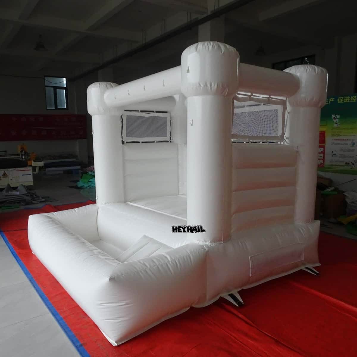 HEYHAIL white 8 x 8 ft bounce house with front ball pit, angled view
