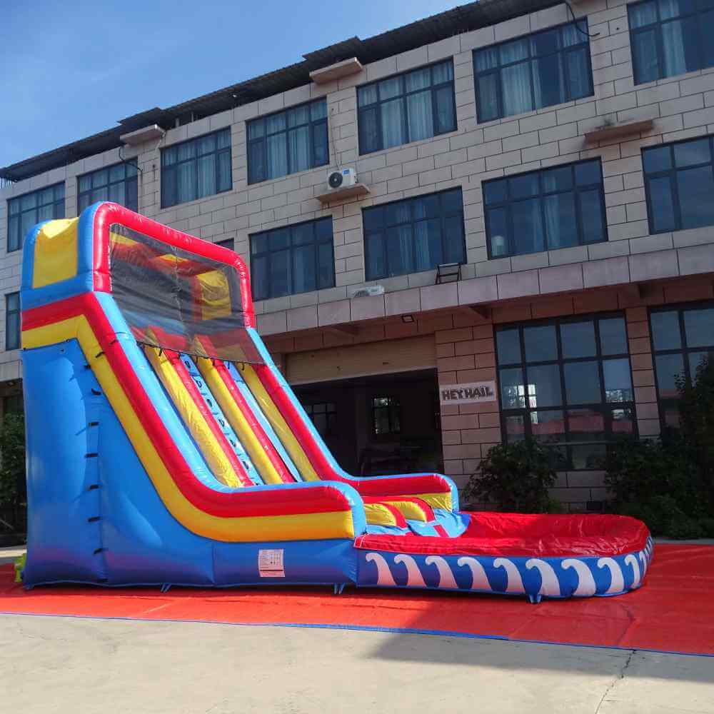 Side view of red blue yellow 22ft dual lane water slide with attached deep pool