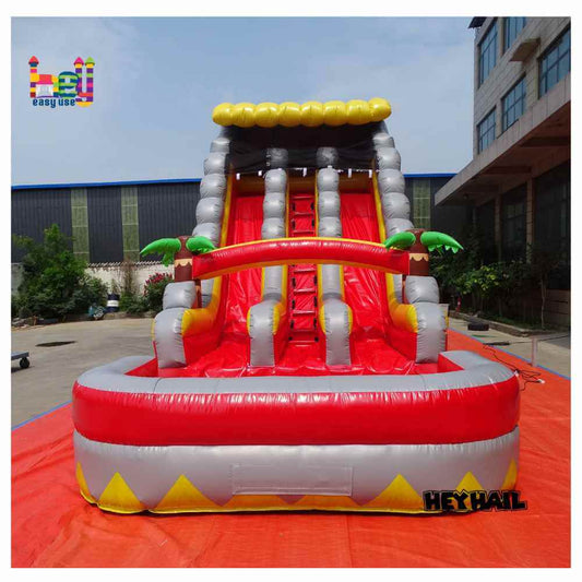 Front view of red, gray, and yellow dual-lane water slide with pool and palm accents
