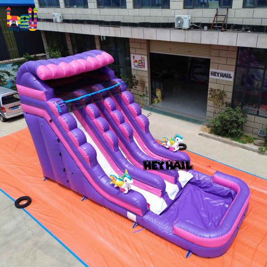 Elevated angled view of purple and pink unicorn dual-lane water slide with pool