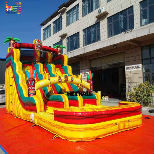 Angled view of colorful tropical dual-lane water slide with pool, palm trees, and tiki-style decorations