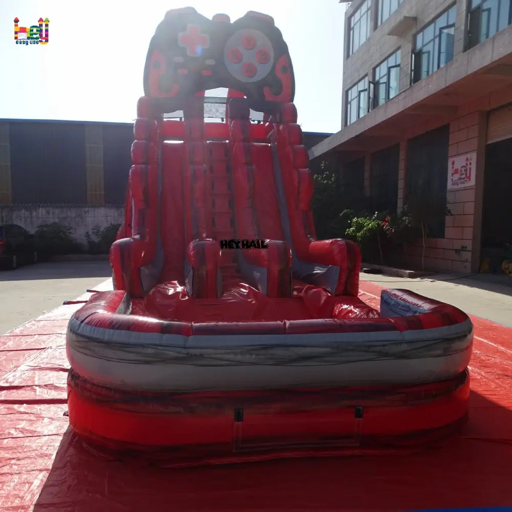 Outdoor front view of a red and gray 20ft dual-lane inflatable water slide with a game-controller arch and landing pool