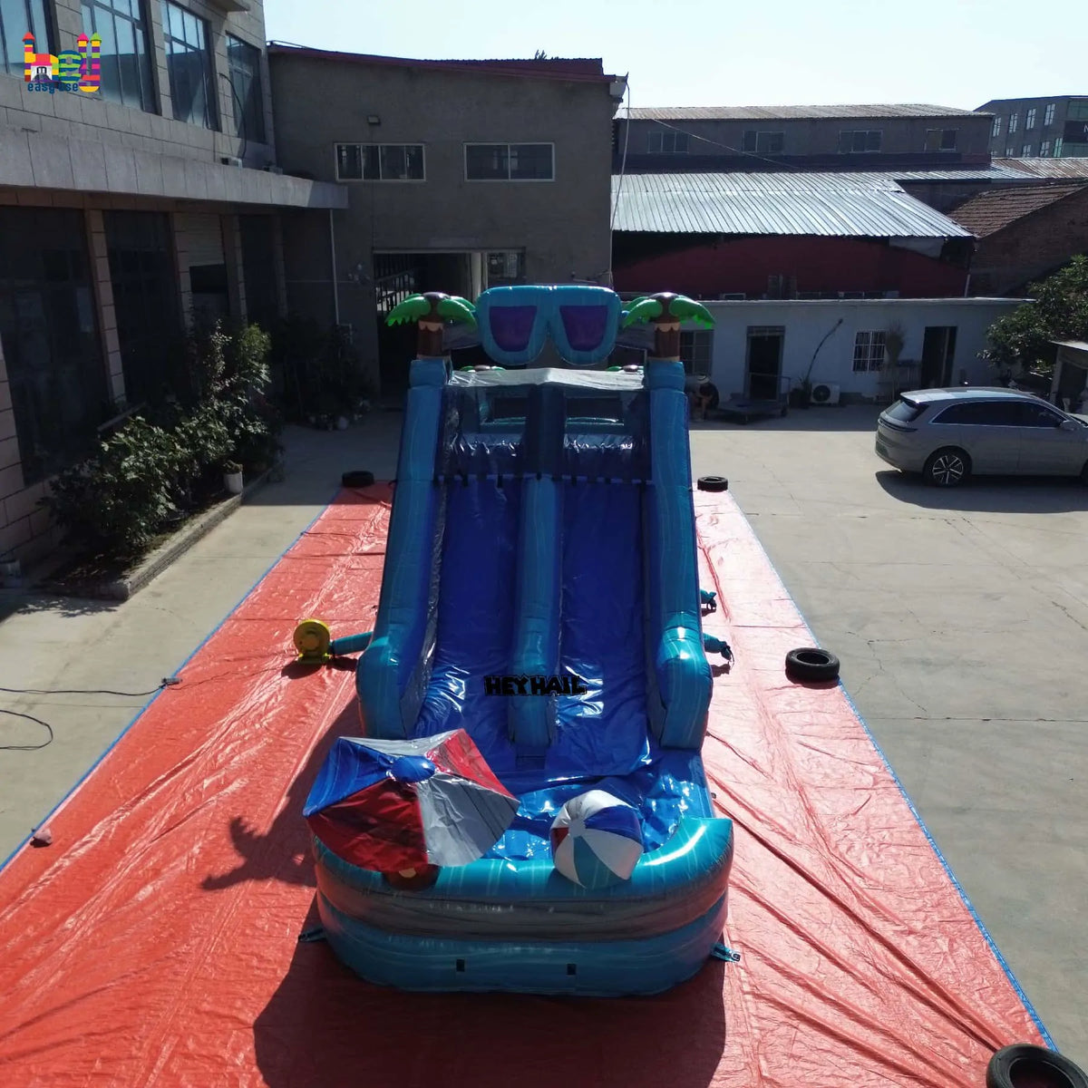 Front view of the tropical dual-lane inflatable obstacle course with a slide