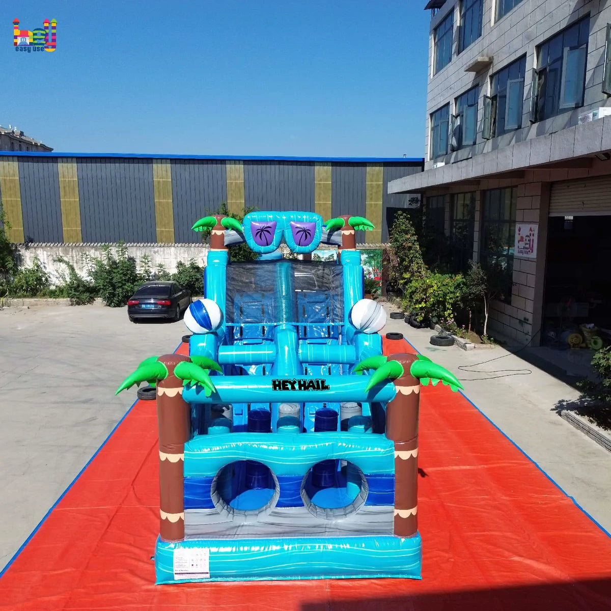 Rear view of the tropical dual-lane inflatable obstacle course with a slide
