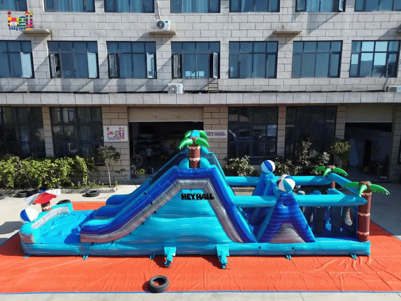 Side view of the tropical dual-lane inflatable obstacle course with a slide