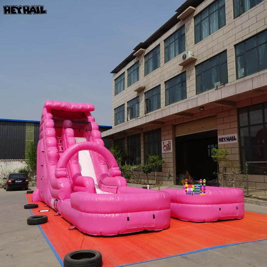 Hot pink commercial water slide with deep pool, side view