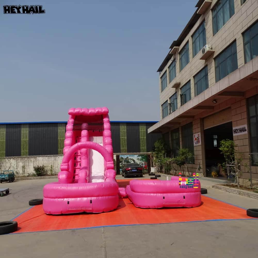 Front view of hot pink commercial water slide with deep pool
