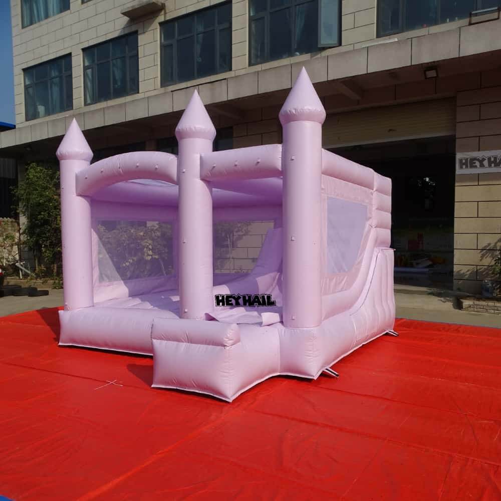 Front-side view of lavender castle-style bounce house with slide