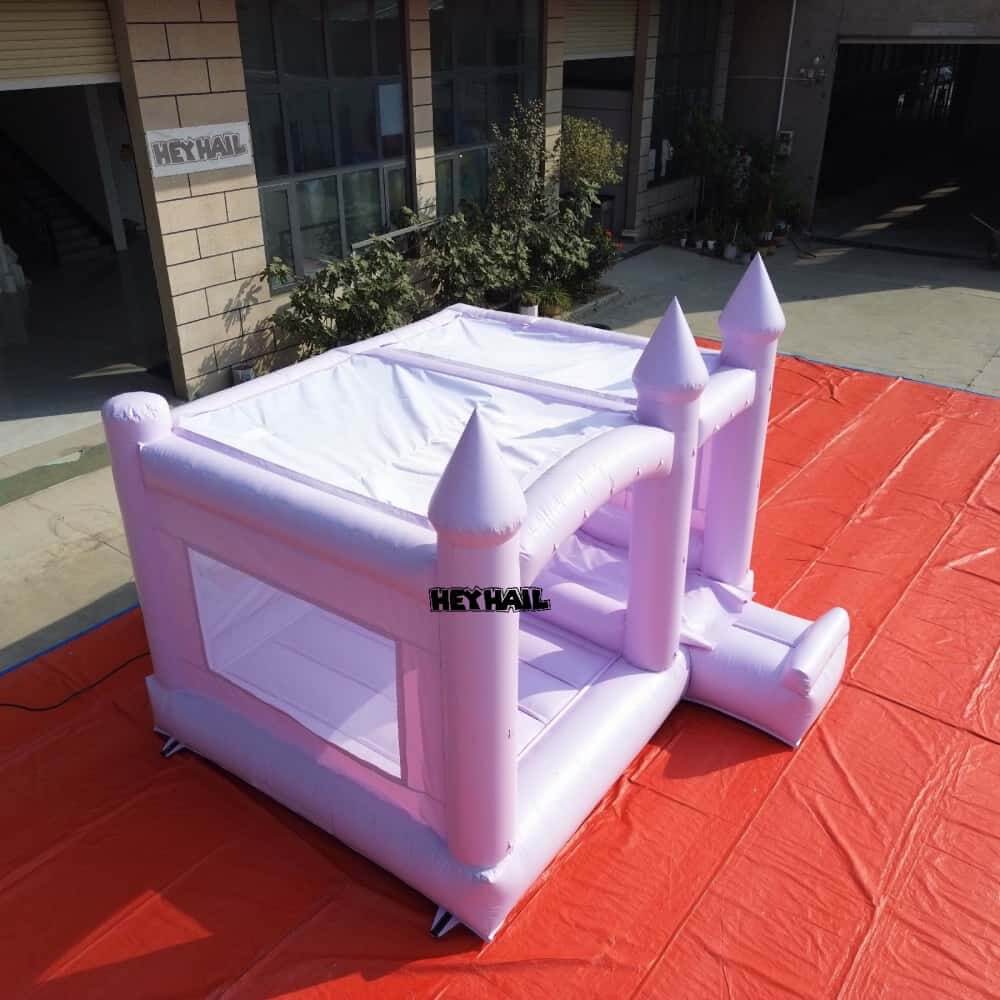 Rear view of lavender bounce house showing mesh side panel and slide