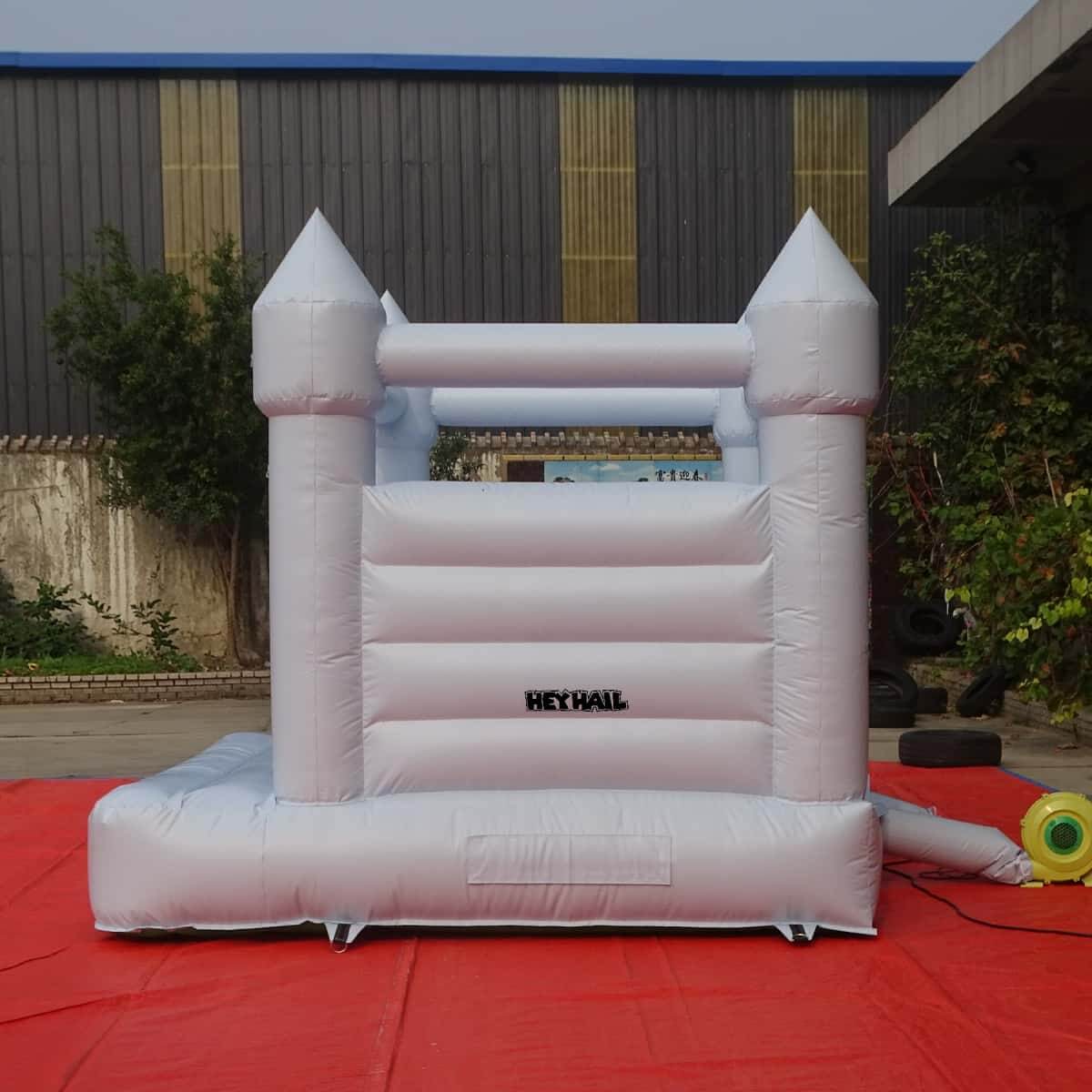 Light pastel blue bounce house rear view with inflation tube